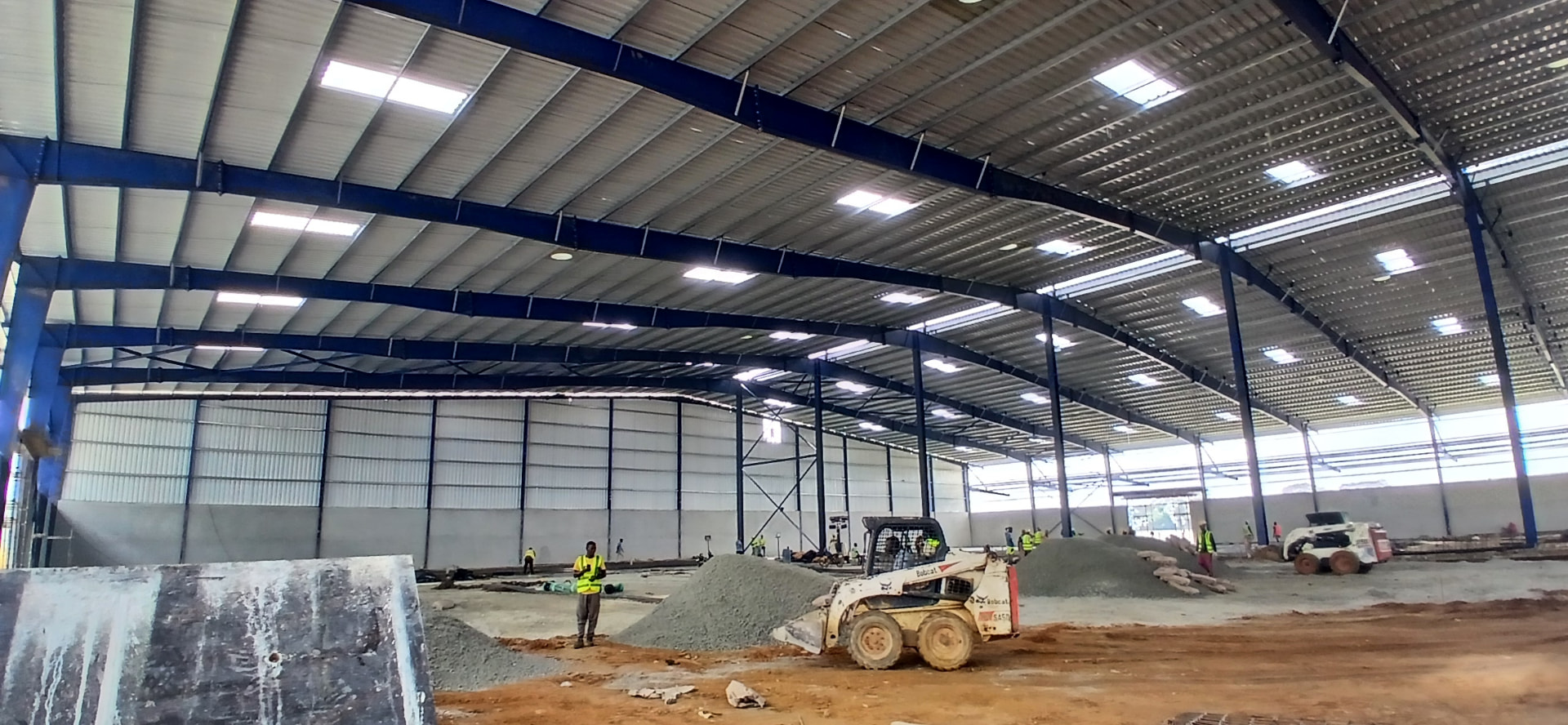 Charpente industrielle 20 000 m² à Yopougon PK24 : structure métallique bleue, pannes, portiques et couverture en cours de finition — vue 3