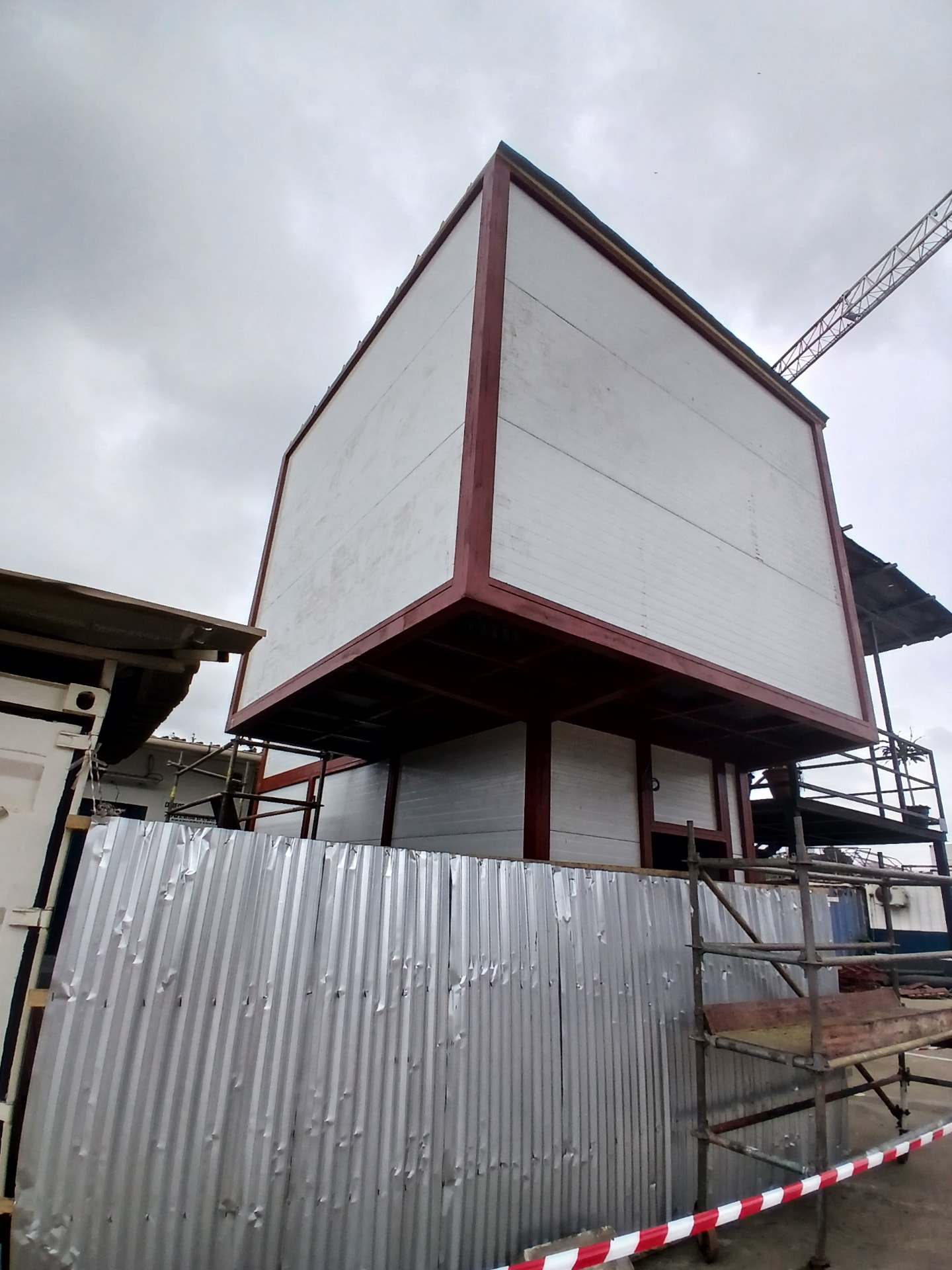 Bureaux préfabriqués R+1 à Abidjan Carena : structure métallique, panneaux sandwichs et bardage blanc en cours de finition — vue 3