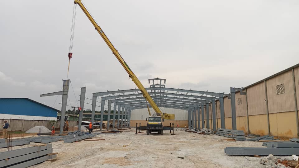Charpente industrielle agroalimentaire 5 001 m² à Bonoua : bardage beige, structure métallique, couverture et montage en cours — vue 8